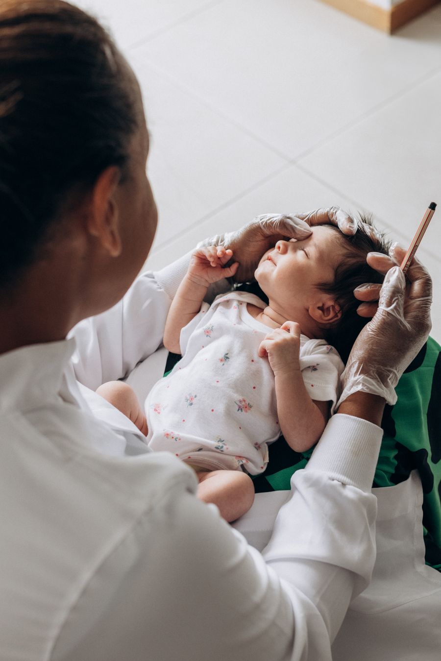 A clinician gently examining a newborn